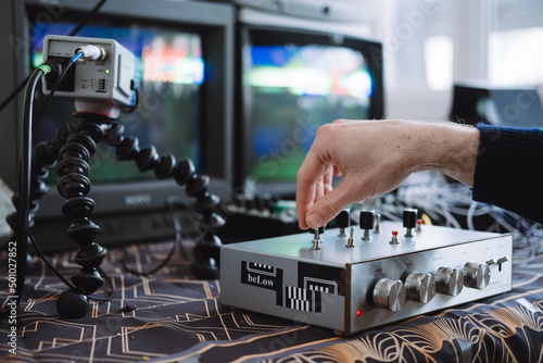 A hand manipulating a custom DIY circuit bent interface to glitch analog VHS signals photo