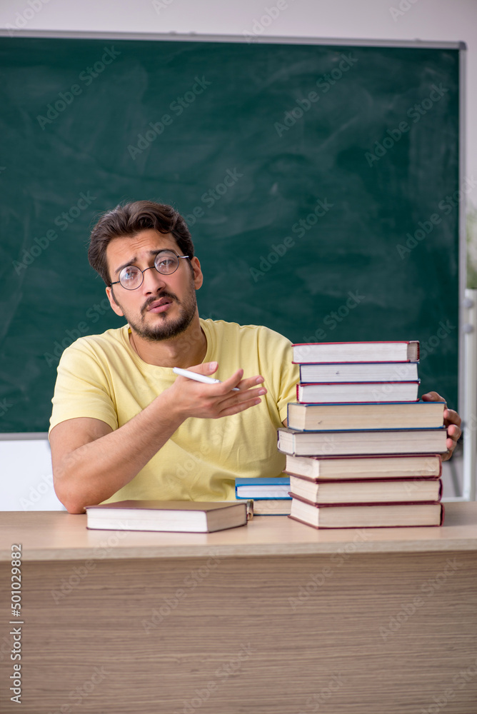 Young male student preparing for exams in the classroom