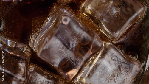 Close-up top view of ice spinning with a carbonated drink