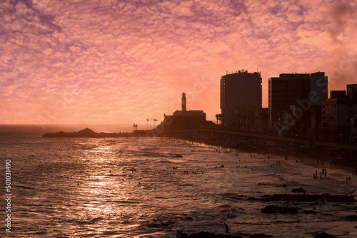 View of the sunset on the beach bar with the Barra Lighthouse in the background.