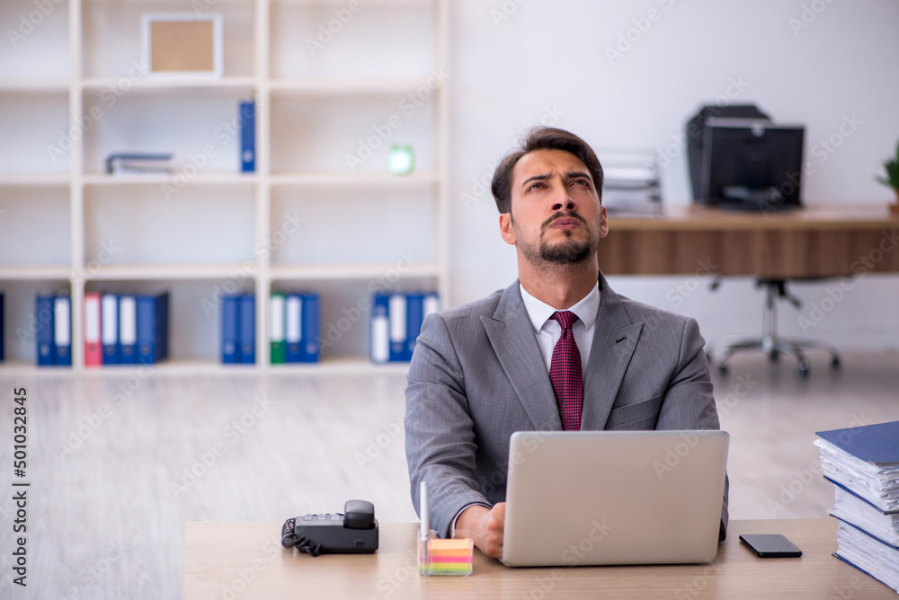 Young male employee working in the office Young male employee working in the office