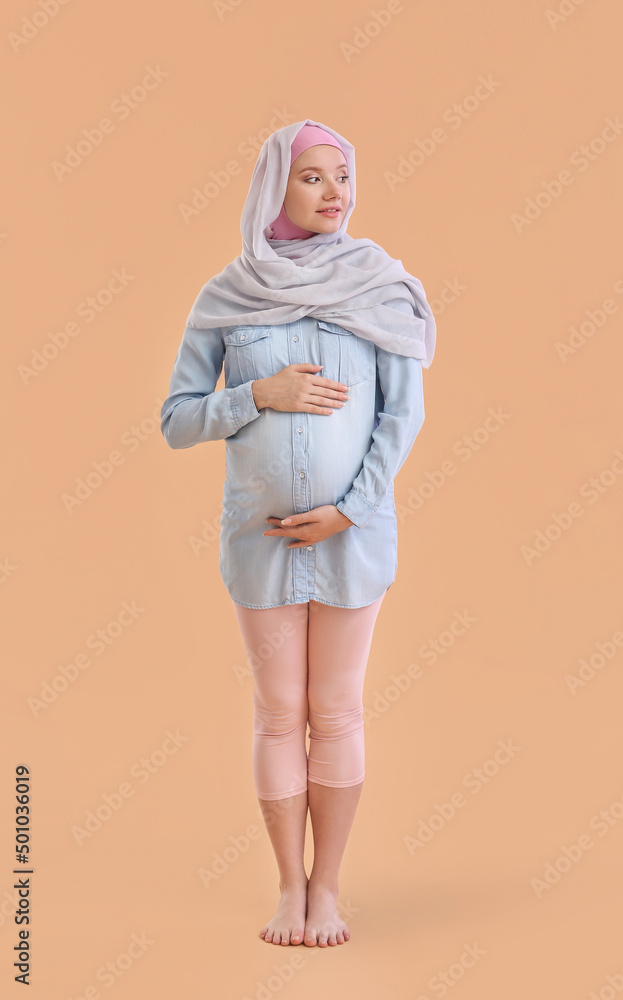 Pregnant Muslim woman on beige background Pregnant Muslim woman on beige background