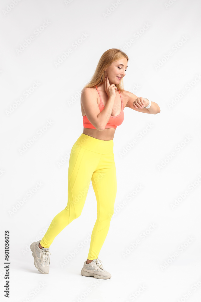 Naklejka premium Female runner checking pulse on light background