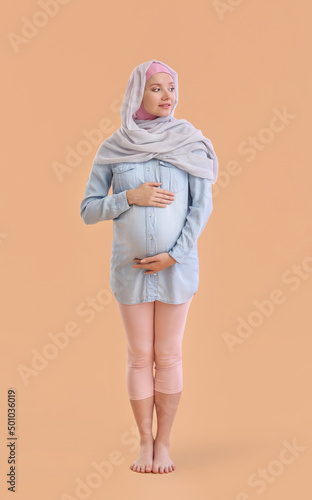 Pregnant Muslim woman on be...