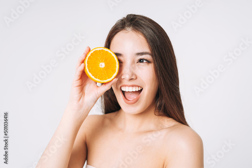 Beauty funny portrait of happy smiling asian woman with dark long hair with oranges in hands on white background isolated