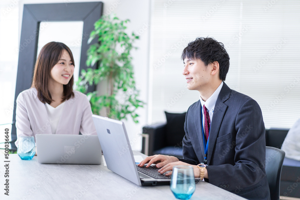 Man and woman talking happily in an office Man and woman talking happily in an office