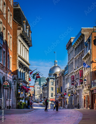 Saint Paul street in old town Montreal on a clear fall day, with the dome of Marché Bonsecours in the background © Pernelle Voyage