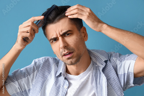 Worried young man combing h...