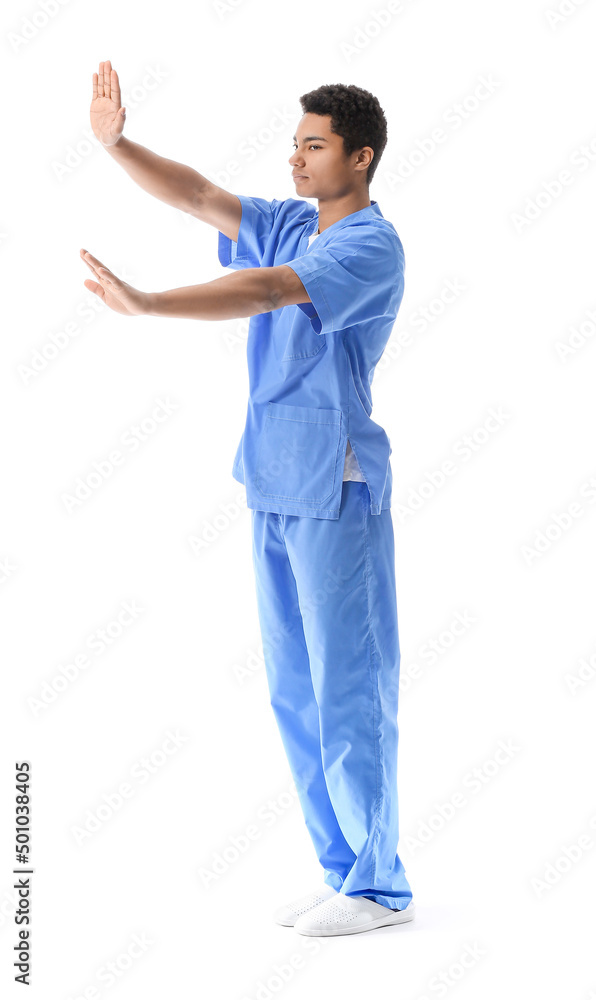 Young African-American doctor showing stop gesture on white background. Immunity concept Young African-American doctor showing stop gesture on white background. Immunity concept