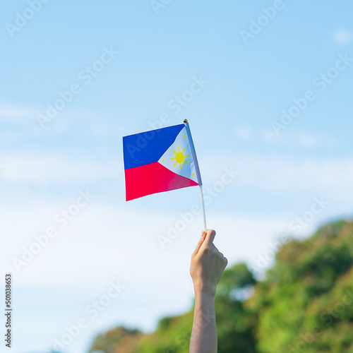 hand holding Philippines flag on nature background. 12th June of Independence day and happy celebration concepts