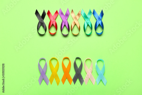 Many awareness ribbons on green background. World Cancer Day concept