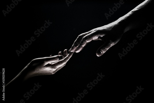 Hands gesturing on black background. Giving a helping hand. Support and help, salvation. Hands of two people at the time of rescue. Romantic touch with fingers, love. Hand creation of adam.