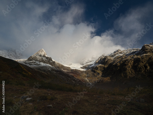 Fototapeta Naklejka Na Ścianę i Meble -  Misty foggy alpine mountains. Cold morning. Tour du Mont Blanc