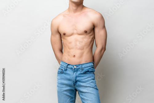 Obraz na płótnie Shirtless muscular male model body on gray isolated background in light studio