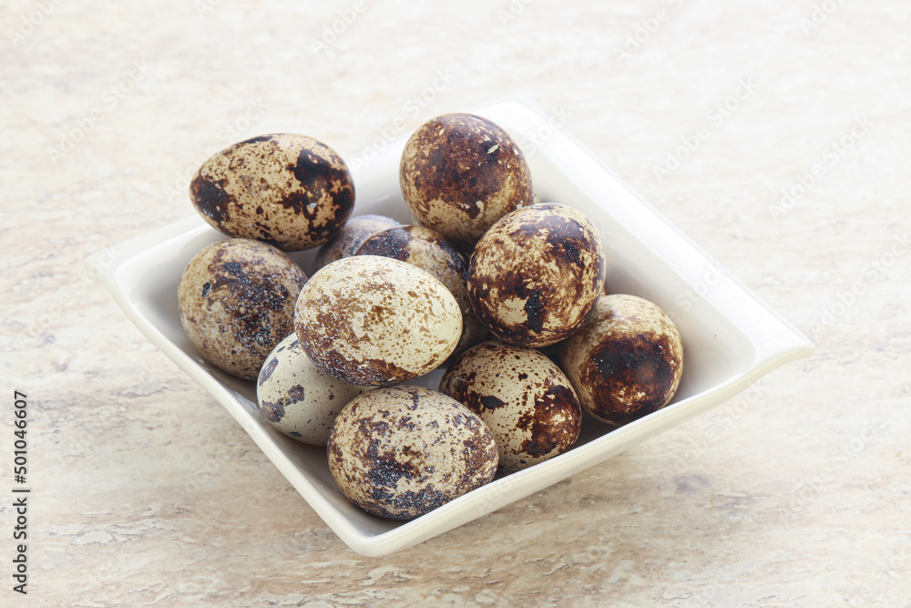 Raw quail eggs heap in the bowl Raw quail eggs heap in the bowl