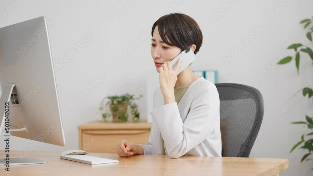 通話相手に謝罪をする若いビジネスウーマン