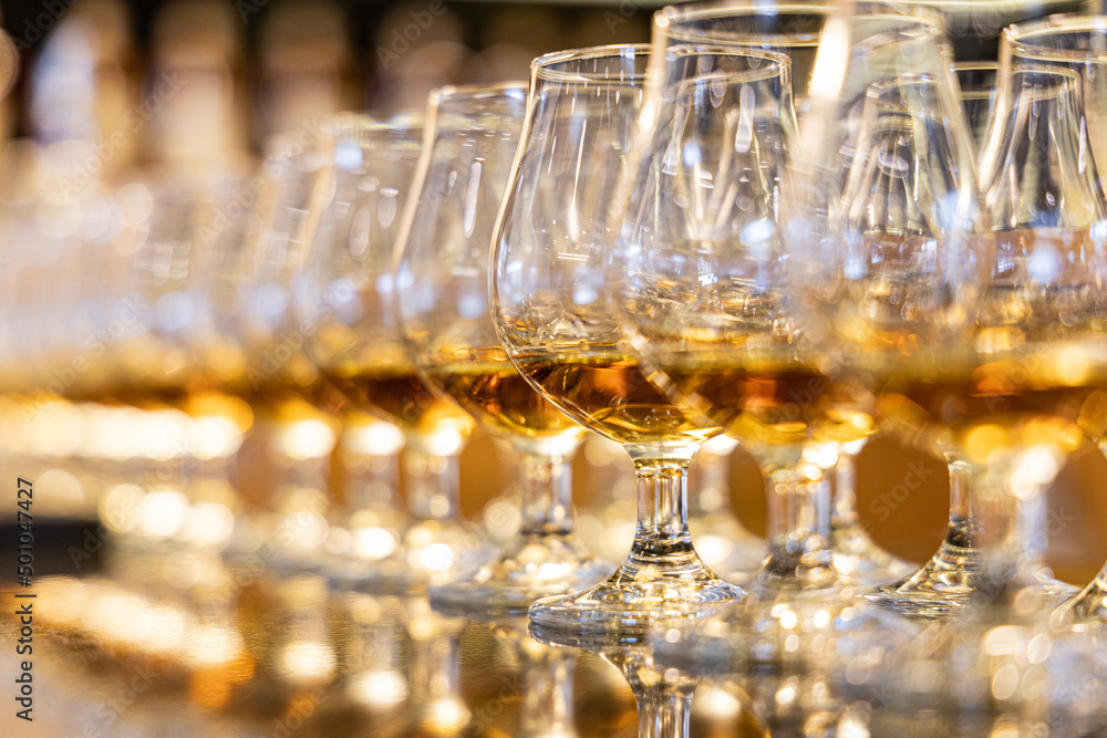 line of whisky glasses filled to taste the old brewed gold. distelery whiskey tasting line of whisky glasses filled to taste the old brewed gold. distelery whiskey tasting