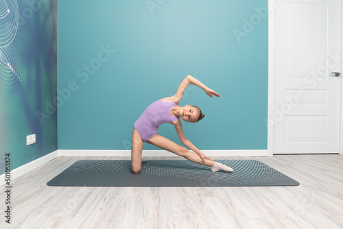 A young girl is engaged in gymnastics. Stretching