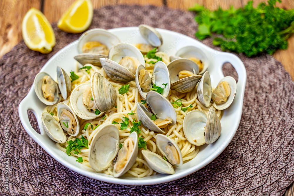 Fresh Littleneck Clams on a white plate with parsley.