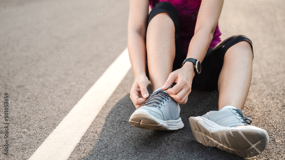 closeup of young woman runner tying her shoelaces. healthy and fitness concept.