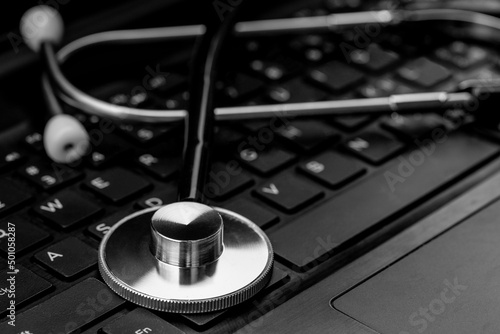 The doctor's stethoscope is placed on the notebook computer.