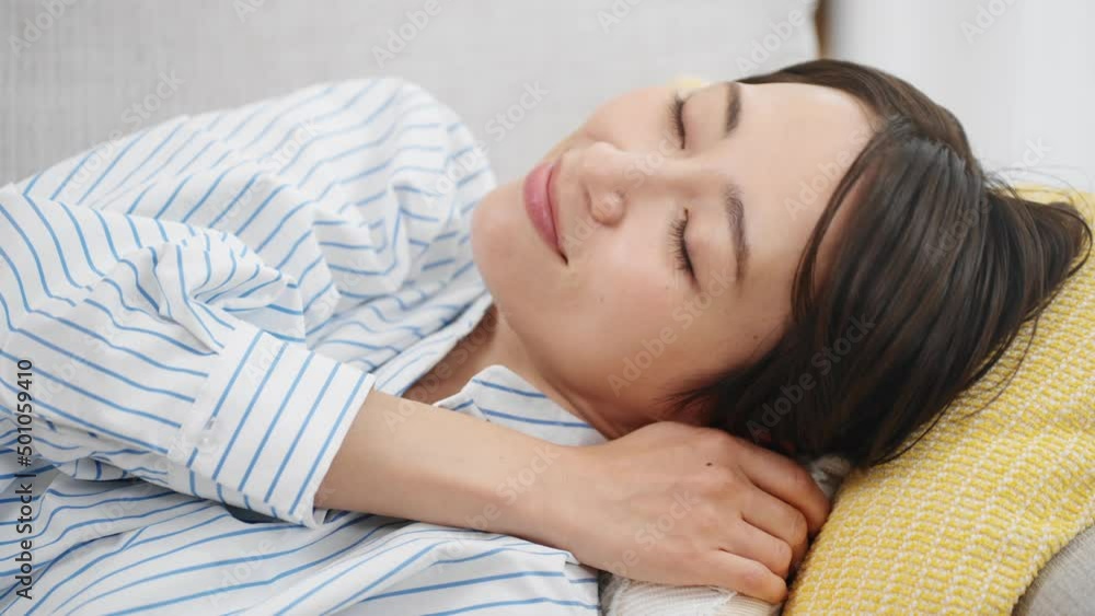 ソファーで昼寝をする若い女性 ソファーで昼寝をする若い女性