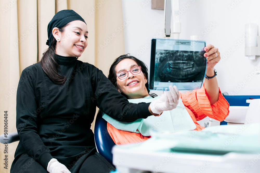 View of dentist with patient reviewing xray. Dentist showing xray to