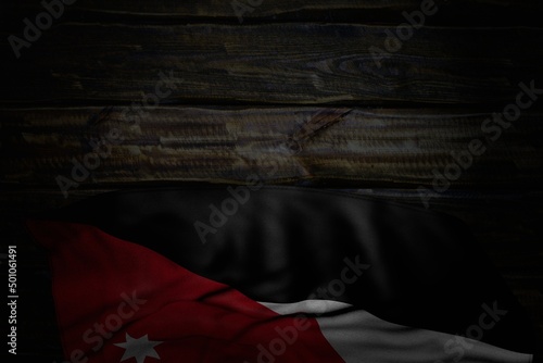 beautiful dark photo of Jordan flag with large folds on old wood with free space for your content - any occasion flag 3d illustration..