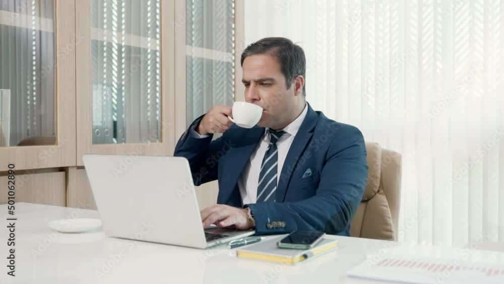 Business man sitting using laptop study online work at his desk success celebration at office, Smiling happy businessman cheerful in casual office making phone call while working with laptop computer Business man sitting using laptop study online work at his desk success celebration at office, Smiling happy businessman cheerful in casual office making phone call while working with laptop computer