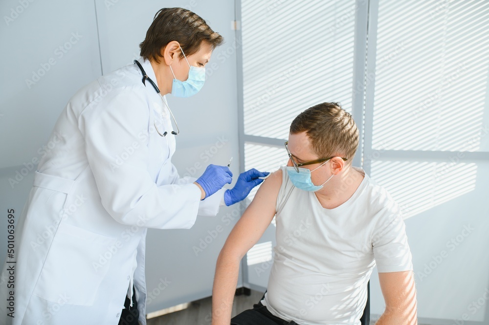 Fototapeta premium Female doctor vaccinating a man