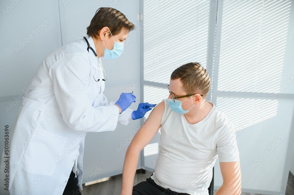 Close up of a Doctor making a vaccination in the shoulder of patient, Flu Vaccination Injection on Arm, coronavirus, covid-19 vaccine disease preparing for human clinical trials vaccination shot. Close up of a Doctor making a vaccination in the shoulder of patient, Flu Vaccination Injection on Arm, coronavirus, covid-19 vaccine disease preparing for human clinical trials vaccination shot.