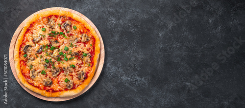 Pizza with mushrooms, cheese and tamatomi on a black background. Top view, copy space.