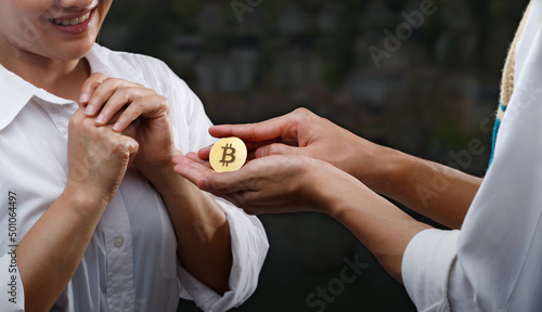 Man give Heart as Bitcoin btc crypto currency to propose woman to married, concept Love Bit coin and marriage life. Gold medal in palm as diamond ring