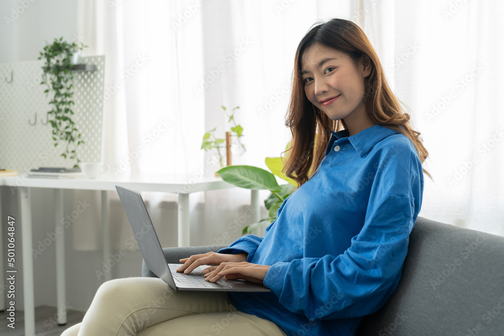 Young asian business woman smile and work from home with laptop computer online to internet on sofa in living room, freelance girl using notebook on couch with comfort, new normal, lifestyle concept Young asian business woman smile and work from home with laptop computer online to internet on sofa in living room, freelance girl using notebook on couch with comfort, new normal, lifestyle concept
