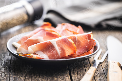 Sliced schwarzwald ham. Dried prosciutto ham on plate. photo