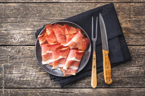 Sliced schwarzwald ham. Dried prosciutto ham on plate. photo
