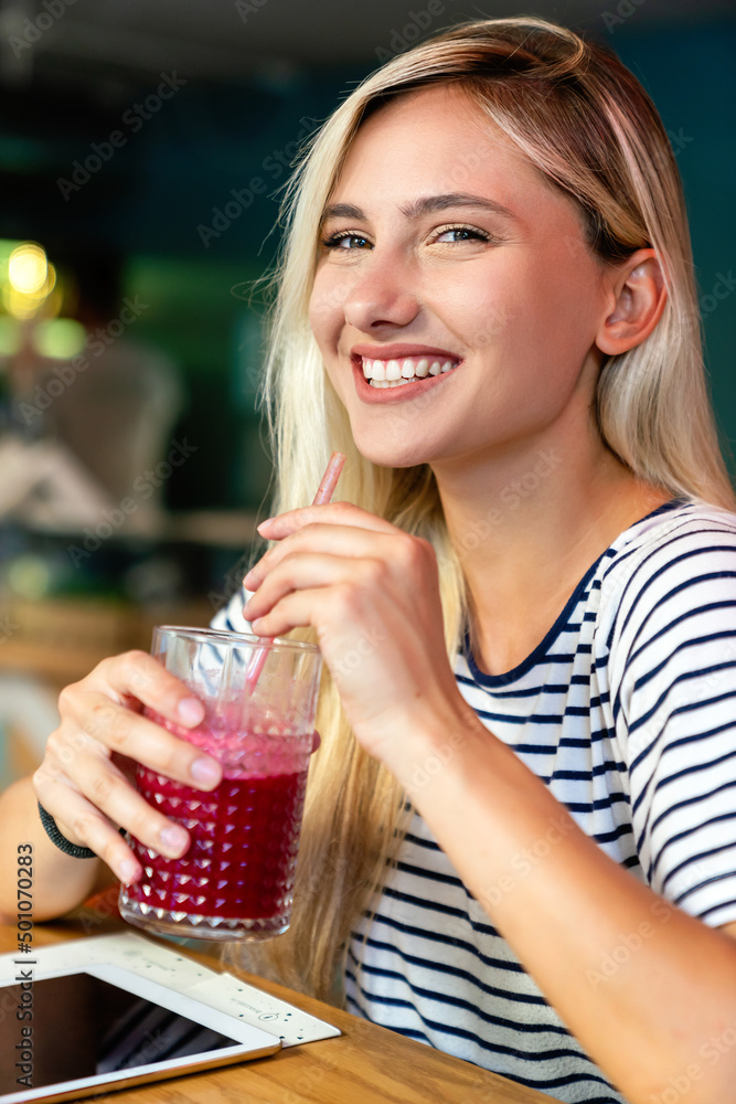 Young woman having a good morning healthy smoothie drink made of super foods. People health concept Young woman having a good morning healthy smoothie drink made of super foods. People health concept