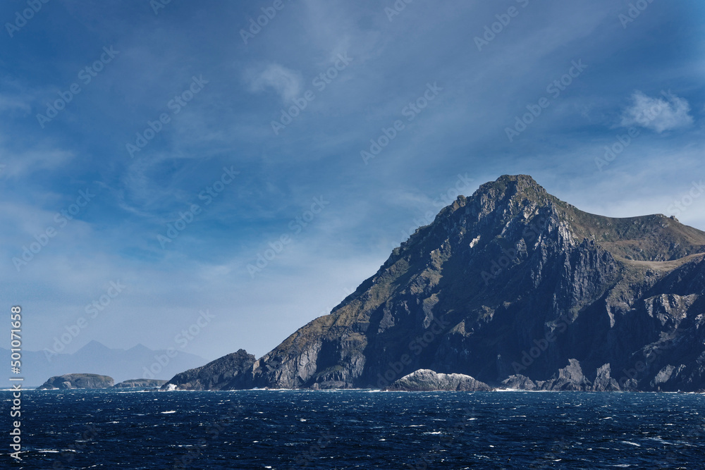 steep cliffs and sea at Cape Horn against blue sky steep cliffs and sea at Cape Horn against blue sky