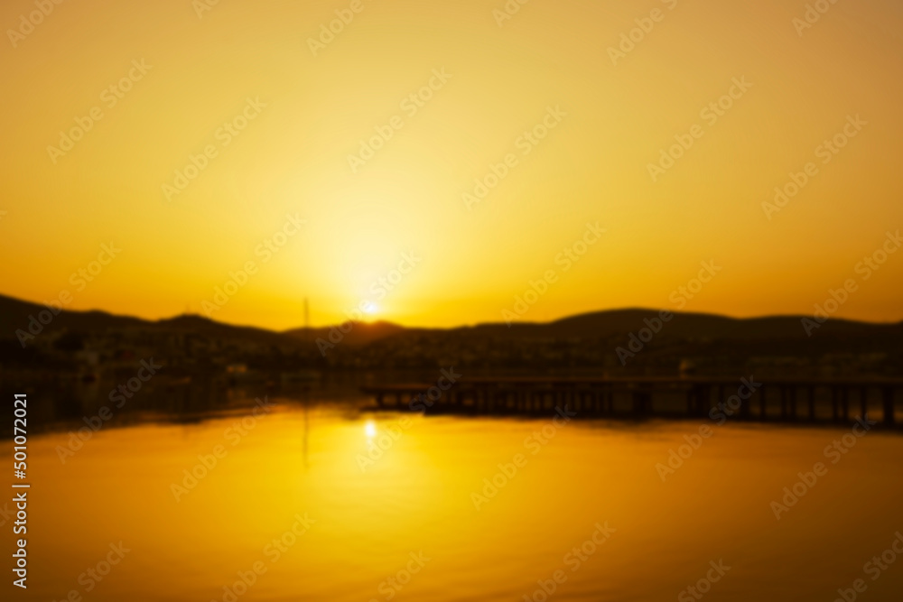 Natural background blurring warm colors and bright sun light, sunset or sunrise.