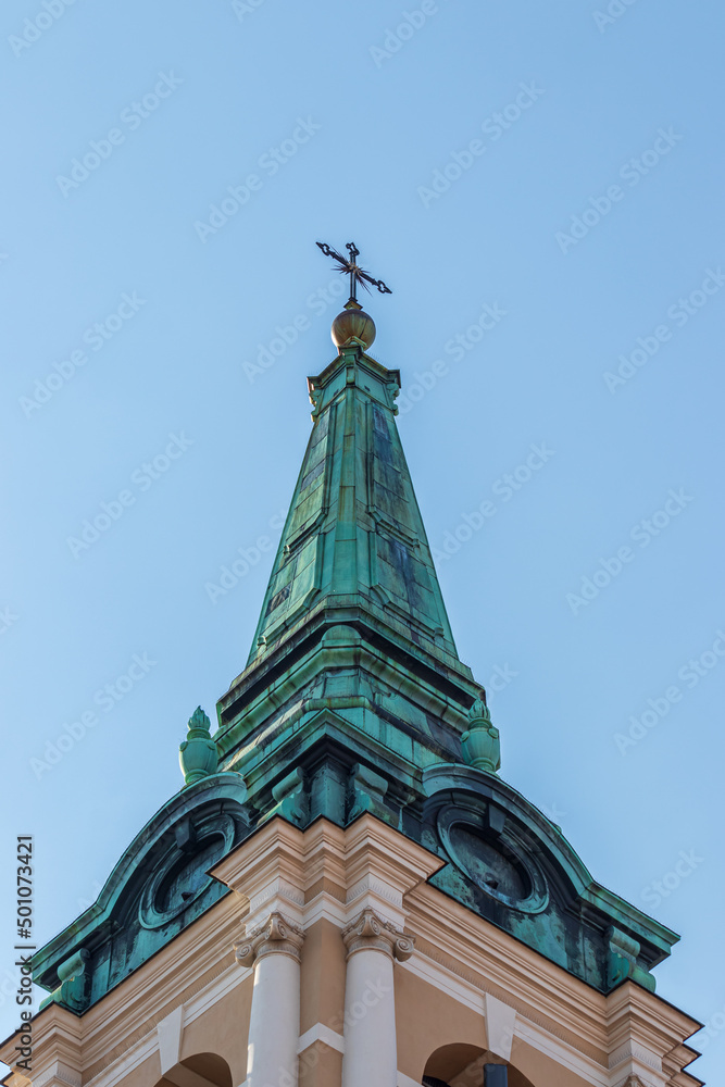 bottom view of the top of the tall tower in Torun, the tall structure of the tower ended with a spike