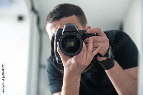 A male photographer takes a photo of himself in the mirror. © puhimec