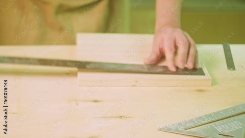 A mature carpenter makes works in his carpentry workshop, measures the wood by molting A mature carpenter makes works in his carpentry workshop, measures the wood by molting