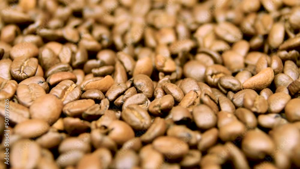 Coffee on black surface. Dense roasted beans of Arabica Robusta Low depth of field. Roasted coffee beans on black background. Beautiful beans arabica robusta. Perfect start of a day. Coffee on black surface. Dense roasted beans of Arabica Robusta Low depth of field. Roasted coffee beans on black background. Beautiful beans arabica robusta. Perfect start of a day.