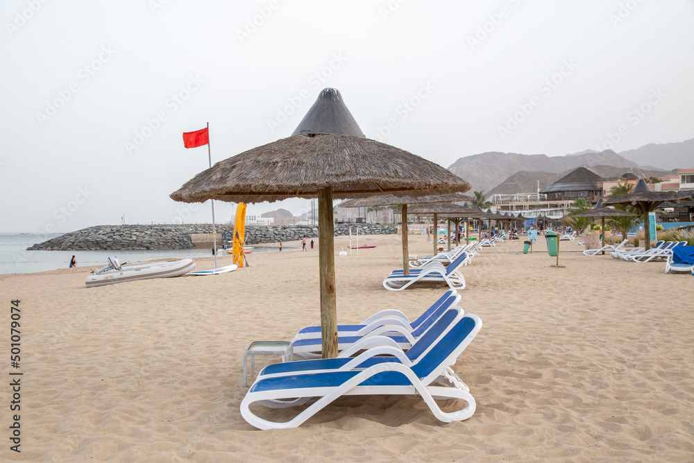 beach with umbrellas and blue chairs out of focus with grain