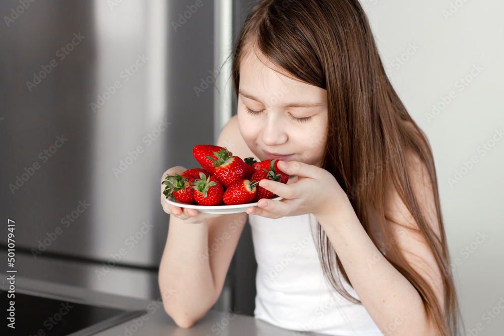 Preteen girl holding raw straberry, eating healthy food, drinking milk Preteen girl holding raw straberry, eating healthy food, drinking milk