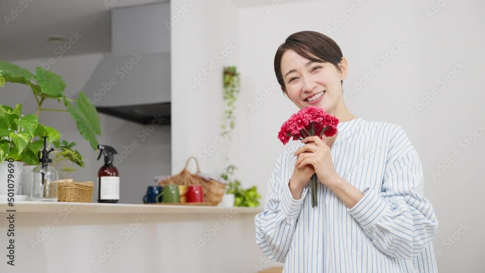 カーネーションを手にする若い女性 母の日のイメージ カーネーションを手にする若い女性 母の日のイメージ