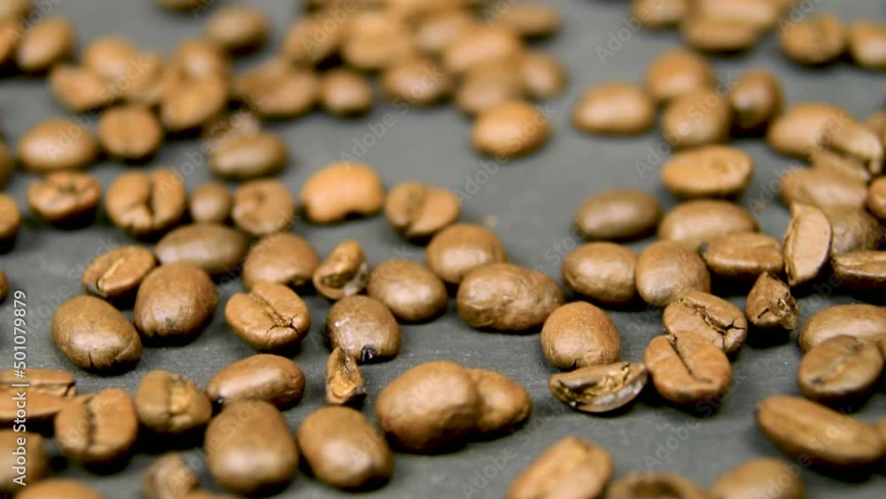 Coffee on black surface. Low depth of field. Roasted coffee beans on black background. Beautiful beans arabica robusta. Perfect start of a day. Coffee on black surface. Low depth of field. Roasted coffee beans on black background. Beautiful beans arabica robusta. Perfect start of a day.