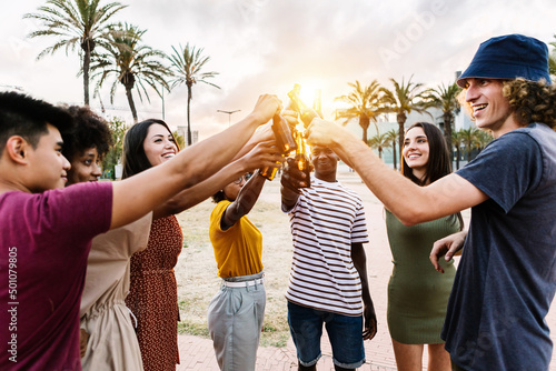 Canvas Print Group of happy young multiracial friends with drinks celebrating in summer party