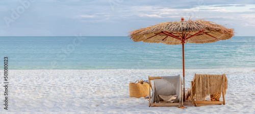 Fototapeta Naklejka Na Ścianę i Meble -  beautiful tranquil white sand beach with two beach chair and thatched umbrella with copy space. romantic summer vacation at tropical private island for luxury sea resort advertising background.