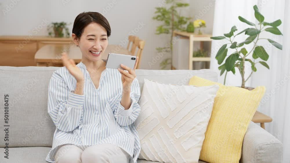 スマートフォンでビデオ通話をする若い女性 スマートフォンでビデオ通話をする若い女性